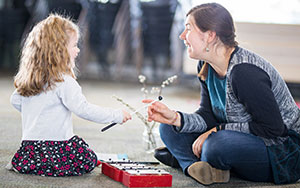 Child and teacher playing a zylaphone