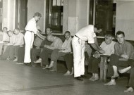 Conscientious objectors (in white) attend to patients in the mental unit of Cleveland State Hospital during World War II. With 2,800 patients in 1945, the hospital was 600 over its capacity. “The hospital had a poor reputation with respect to patient care,” according to The Civilian Public Service Story at http://civilianpublicservice.org, “Workers had to fight cockroaches and filth in overcrowded wards, and [non-CPS] attendants controlled patients by shouting and beatings. The ‘incontinent and violent’ wards lacked sufficient supplies or activities for patients and experienced reports of injuries to patients and employees.”