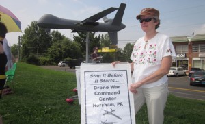 Sue Glick '80 (above) of Akron, Pa., has joined hands with fellows alums Daniel and Marie Riehl of Lititz, Pa., to raise awareness of the destructive application of drone technology in the world. Here a model drone is on display near a proposed drone command center in Horsham, Pa. (Photo by H.A. Penner)