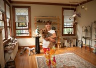 Jean Handley holds her dog in her living room, where a few pieces of art salvaged from her new Orleans home can be seen, along with newly produced items. Her Memphis house remains sparsely furnished, as she  pieces together her post-Hurricane Katrina life.