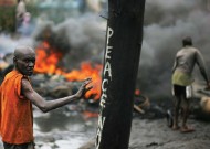 A man passes near a burning barricade in the Kibera section of Nairobi on January 18, 2008. Photo by Roberto Schmidt/AFP/Getty Images.
