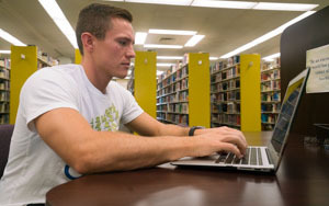 student working at a computer in the library