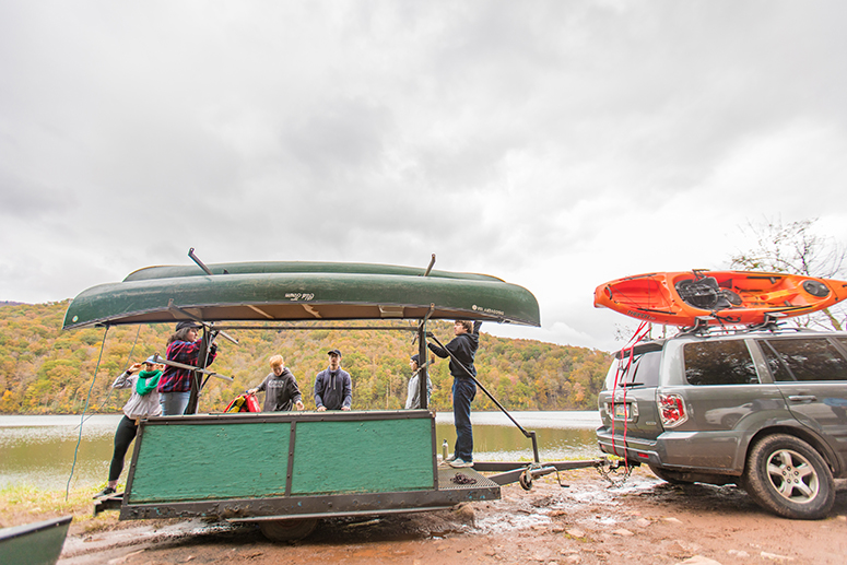 students unloading canoes from a trailer