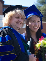 Kim Brenneman at graduation posing with a student