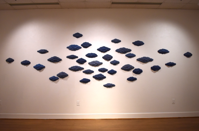 small blue cloud sculptures on the wall