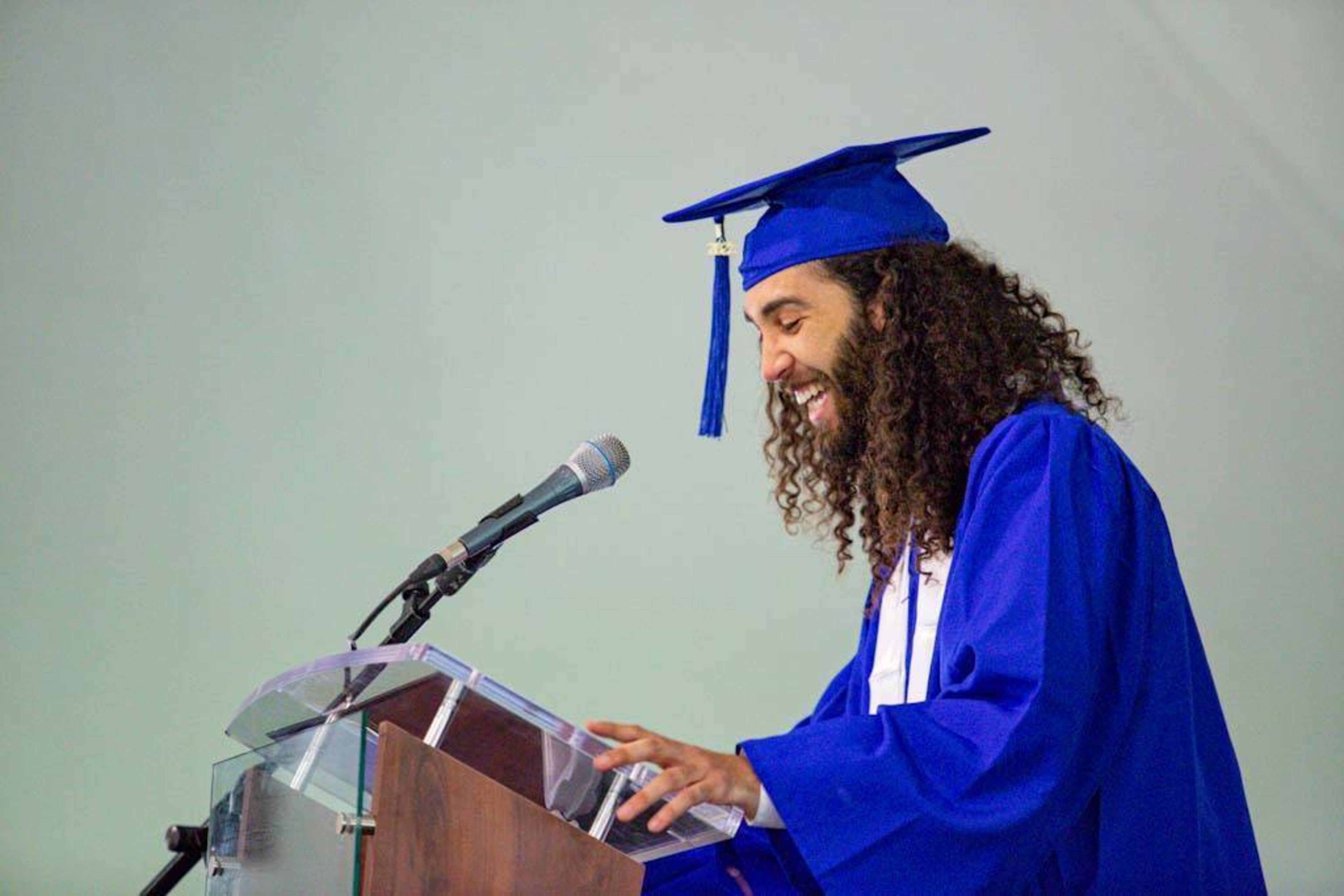 a graduating student laughs at the podium