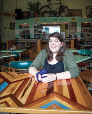 Alice Wheeler, who studied social work at EMU 2008-10, works part-time at The Little Grill while pursuing her dream of being a certified midwife. Here she sits at a table created out of reclaimed wood by Kurt Rosenberger, a 2006 art major who operates Grey Fox Design Works.