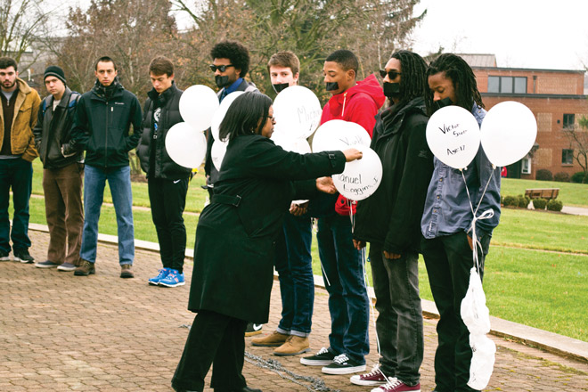 (From left) Yonatan Daniel, Matej Gligorevic, Richard Robinson, Londen Wheeler, and Christian Parks stand in duct-taped silence, holding balloons that Celeste Thomas pops to symbolize deaths. (Photo by Randi B. Hagi)