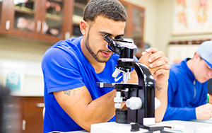 student looking into a microscope